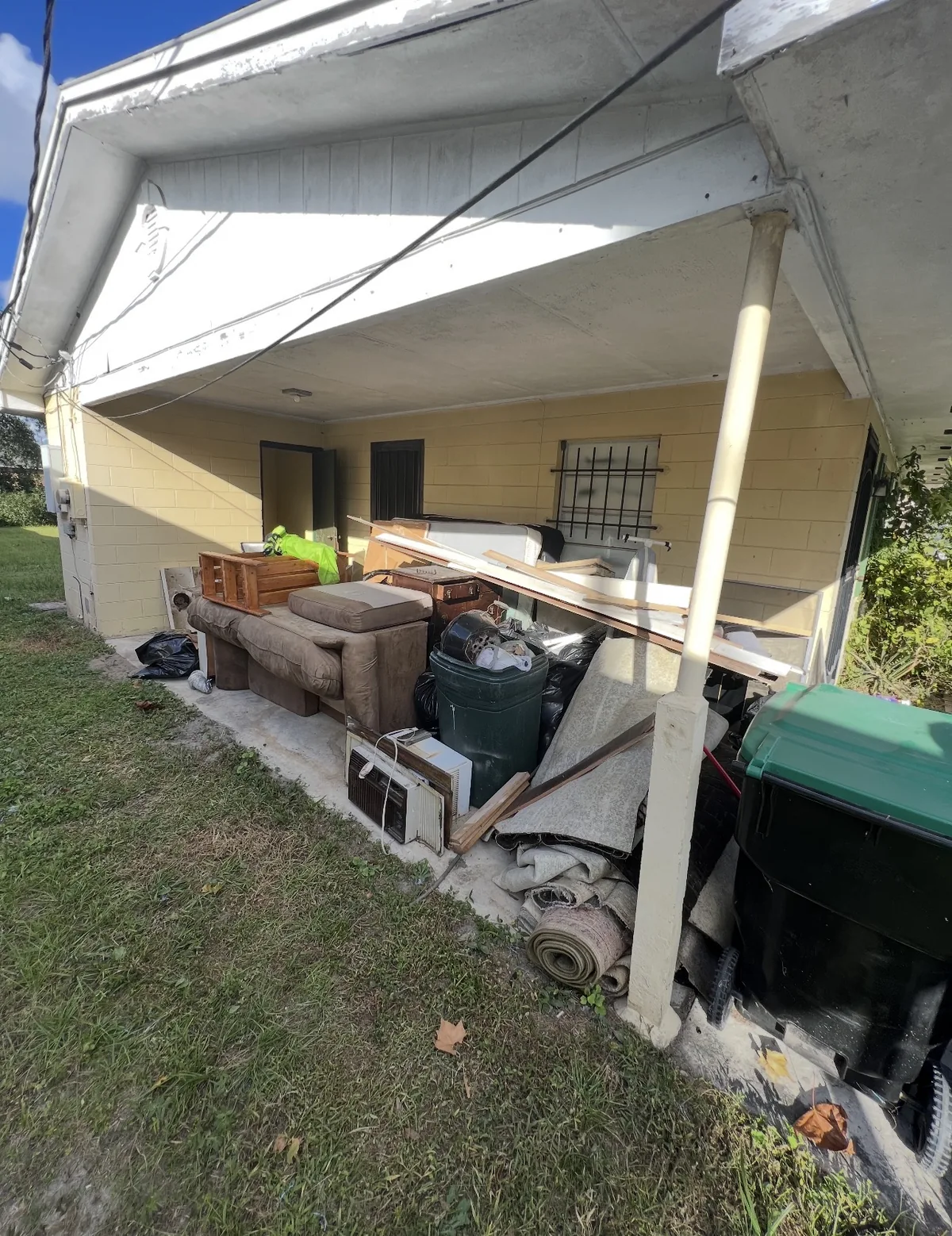 Carport still holding items staged for pickup during Ancient City Junk Removal cleanout
