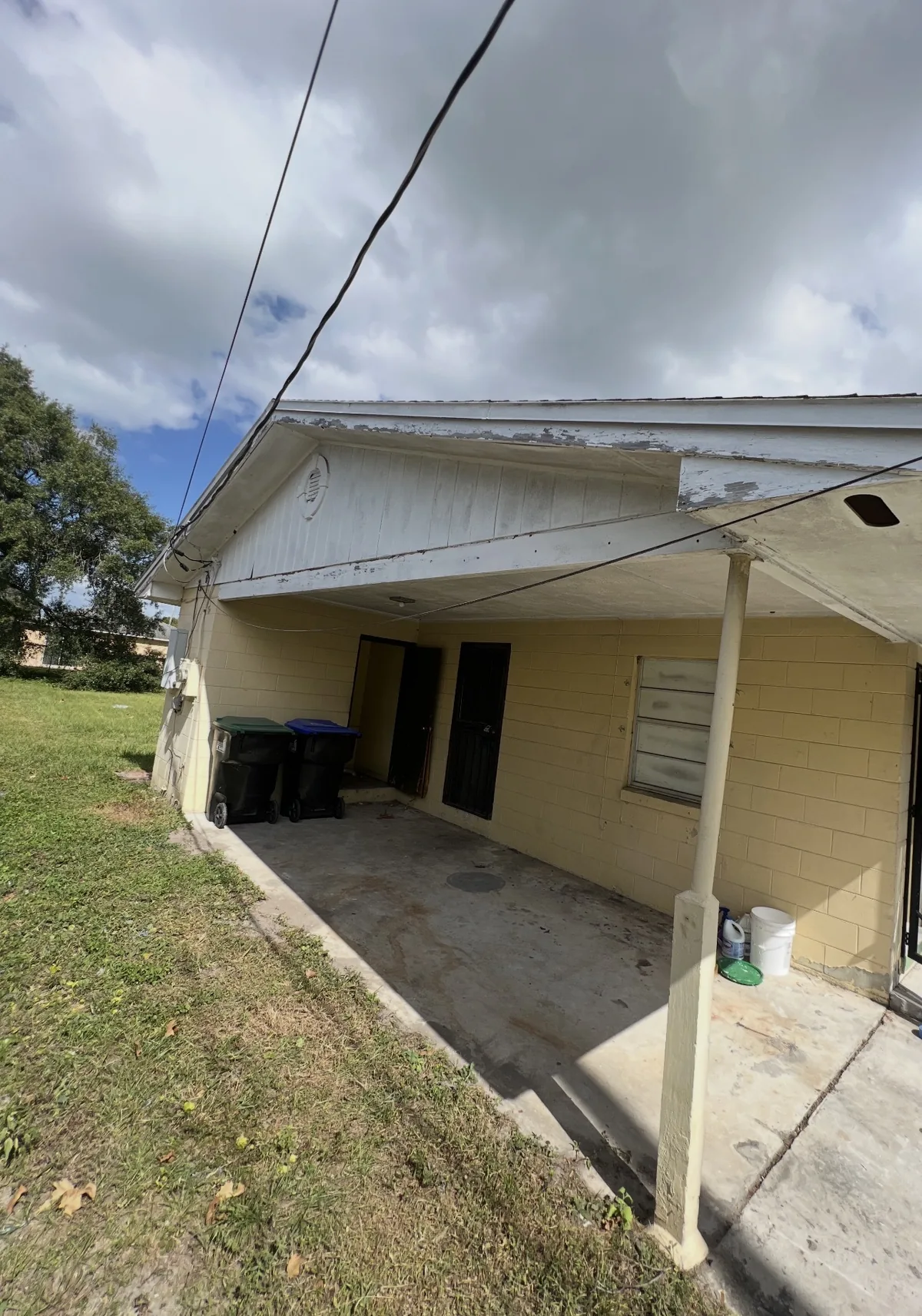 Cluttered carport before Ancient City Junk Removal cleanout